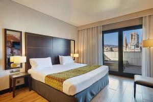 a hotel room with a bed and a large window at Eurostars Monumental in Barcelona