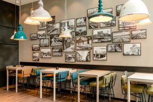 a room filled with tables and chairs with pictures on the wall at Motel One Berlin-Hauptbahnhof in Berlin