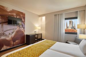 a hotel room with a bed and a flat screen tv at Eurostars Monumental in Barcelona