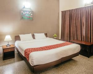 um quarto de hotel com uma cama grande e uma janela em Hanu Reddy Residences Wallace Garden em Chennai