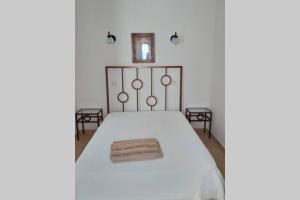 a bedroom with a white bed with a metal headboard at Casa do Avô in Albufeira