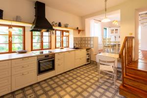 a kitchen with white cabinets and a table in it at Weissenbacherhof in Oslip