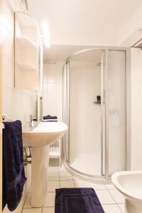 a white bathroom with a shower and a sink at Weissenbacherhof in Oslip