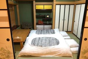 a bedroom with two beds and a balcony at Higashiyamaan in Takayama