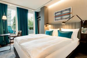 a hotel room with a large bed and a large window at Motel One Berlin-Hauptbahnhof in Berlin