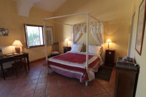 a bedroom with a canopy bed and a desk at Domaine de la Queyssie in Saussignac