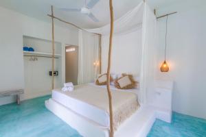 a white bedroom with a bed with a swing at Guru Canggu in Canggu