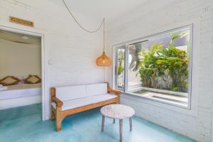 a bench in a room with a window and a stool at Guru Canggu in Canggu