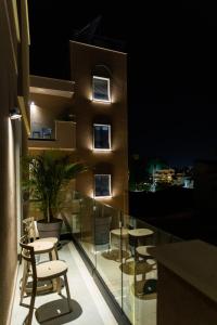 a balcony with chairs and tables on a building at night at Old Port Hotel in Limassol