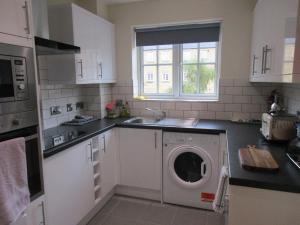 a kitchen with a washing machine and a sink at 20 Nightingale Gardens, Coton Park, Rugby CV23 0WT in Rugby