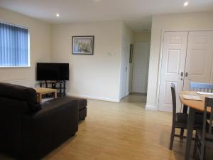 a living room with a couch and a table at 20 Nightingale Gardens, Coton Park, Rugby CV23 0WT in Rugby