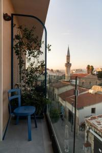 a blue chair on a balcony with a view of a city at Old Port Hotel in Limassol