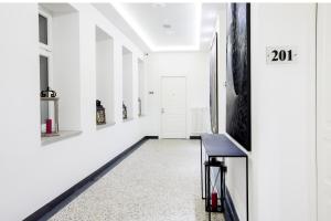 a hallway with white walls and a black and white rug at White House Bela Hiša in Ljubljana