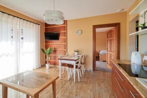 a kitchen with a table and a dining room at Apartamenty Smrek Poronin in Poronin