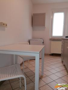 a kitchen with a white table and a chair at Ferienwohnung Karl 54 in Gelenau