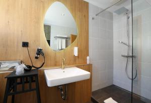 a bathroom with a sink and a shower at Arthotel ANA Goggl in Landsberg am Lech