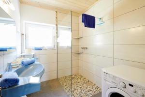 a bathroom with a sink and a washing machine at Bettys Ferienwohnung in Grafenweg