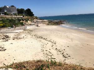 einen Strand mit Fußabdrücken im Sand und im Ozean in der Unterkunft O Bord de la mer in Saint-Pierre-Quiberon