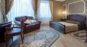ein Schlafzimmer mit einem Bett, einem Sofa und einem Stuhl in der Unterkunft Hotel Helicopter in Krementschuk