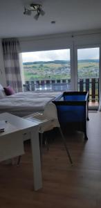 een slaapkamer met een bed, een tafel en een raam bij Loreley Lounge in Patersberg
