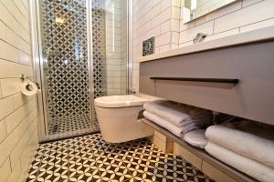 a bathroom with a shower and a toilet and towels at The Row Taksim Hotel in Istanbul +39 photos