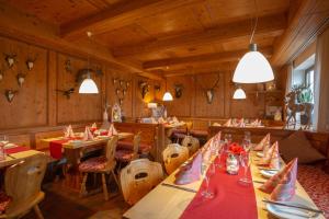 un restaurante con mesas de madera, sillas y luces en Landidyll Hotel Zum Alten Schloss, en Kirchensittenbach