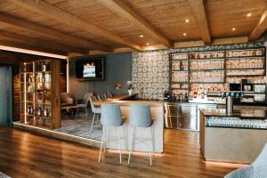 a bar with blue stools in a room at Gasthof Buglhof in Sankt Englmar