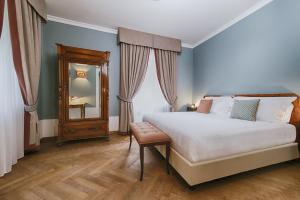 - une chambre avec un grand lit et un miroir dans l'établissement Albergo Posta Marcucci, à Bagno Vignoni