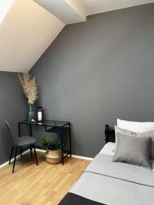 a bedroom with a bed and a table and a chair at Apartman Kelava in Vukovar