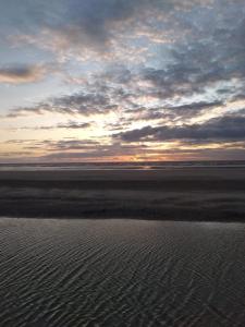 a sunset over the water with a cloudy sky at Sea-front Apartment home-from-home in Blackpool