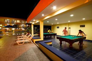 Hotel Club del Sol في أتاكاميس: شخصان يلعبان البلياردو في الغرفة