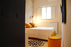 Dormitorio pequeño con cama y ventana en Colorful Pied-à-Terre _ Via Gioberti, en Florencia
