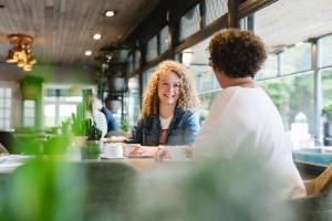 two women sitting at a table in a restaurant at Hotel Restaurant De Wolfsberg in Groesbeek