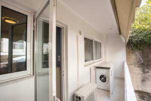 una lavanderia con lavatrice accanto a una finestra di AthensBlues Kolonaki 2 Bedroom with Car Park ad Atene