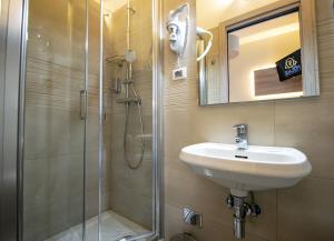 a bathroom with a shower and a sink and a mirror at Hotel Perlage Florence in Scandicci
