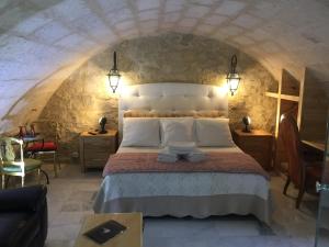 ein Schlafzimmer mit einem großen Bett in einer Steinmauer in der Unterkunft Casa La Palma II La Courmellette in Soissons