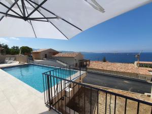 a view of a swimming pool from the balcony of a house at St-Florent Appartement neuf vue mer panoramique piscine 4 chambres - MOR401 in Saint-Florent