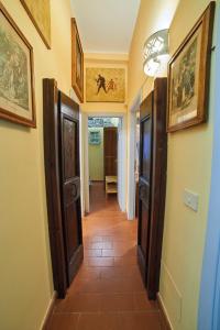einen Flur mit Türen und Gemälden an den Wänden in der Unterkunft Alloggio Turistico Centro Storico Malatesta in Montefiascone