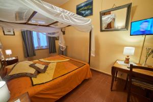 ein Schlafzimmer mit einem Himmelbett und einem Schreibtisch in der Unterkunft Alloggio Turistico Centro Storico Malatesta in Montefiascone