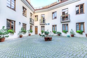 une cour d'un bâtiment avec des plantes en pot dans l'établissement Dysnos Avenue Apartments, à Vilnius