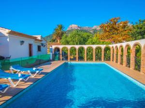 a swimming pool with two chairs and a house at Villa Perles - Plusholidays in Calpe