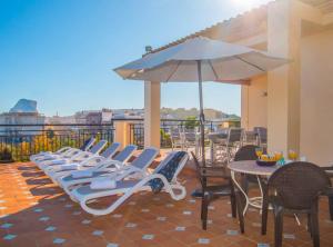 a row of chairs and an umbrella on a patio at Villa Perles - Plusholidays in Calpe