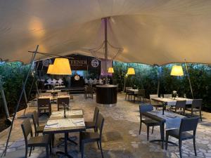 a dining tent with tables and chairs and lights at Hotel Naitendì in Cutrofiano