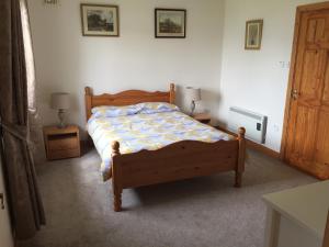 a bedroom with a wooden bed and two night stands at Cliff View, 2 Knockrahaderry in Liscannor