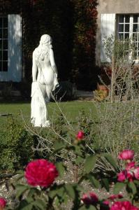 a statue of a woman in a garden with flowers at Domaine de la Queyssie in Saussignac