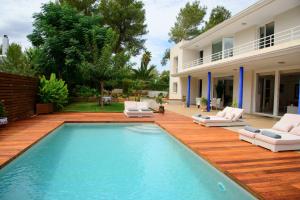 a backyard with a swimming pool and a house at Villa Can Sala in San Antonio Bay