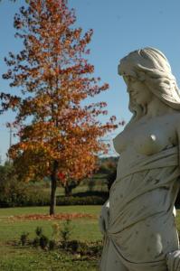 une statue d'une femme dans un parc avec un arbre dans l'établissement Domaine de la Queyssie, à Saussignac
