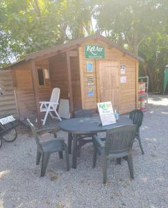 a picnic table and chairs in front of a cabin at Mobile Homes by KelAir at Camping L'Hippocampe in Argelès-sur-Mer
