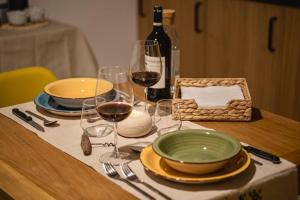 una mesa con platos y copas de vino. en DIMORI Guest House, en Altamura