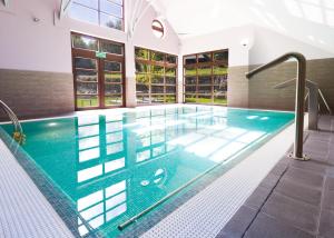 a pool in a building with an indoor swimming pool at Boutique Hotel Sudetia - Medical & SPA in Świeradów-Zdrój